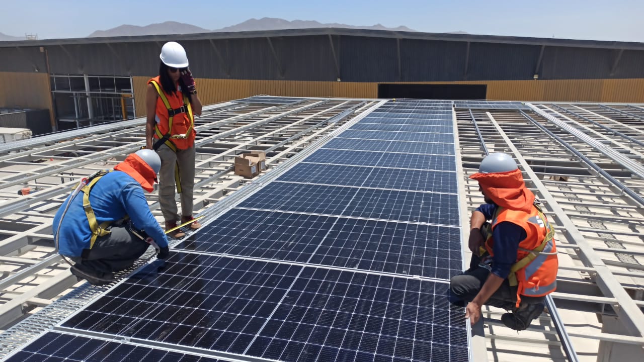 Equipo de SOLEI montando paneles solares en el techo de una planta industrial